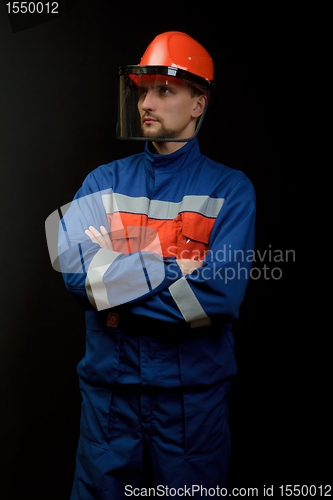 Image of The worker in overalls and a helmet