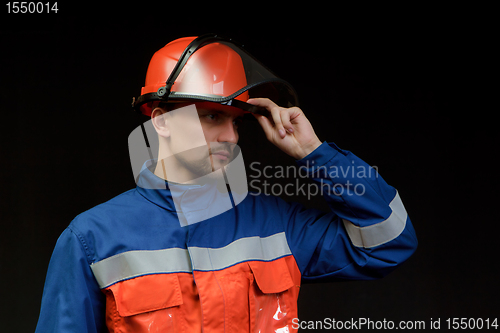 Image of The worker in overalls and a helmet