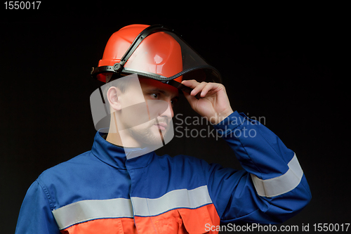 Image of The worker in overalls and a helmet