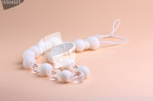 Image of White beads at pink background