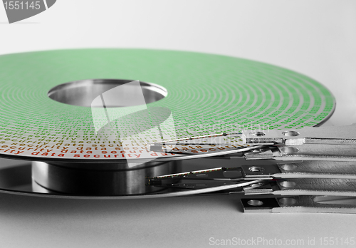 Image of parts of hard disk drive with information on magnetic surface