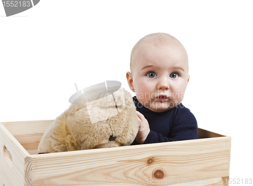 Image of young child with toy in wooden box