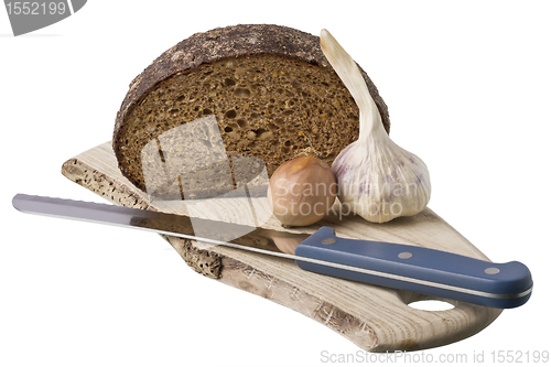 Image of brown bread on shelf with onion and garlic