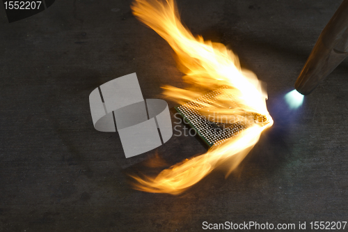 Image of burning a computer chip with welding torch