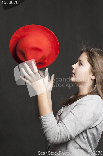 Image of Girl is throwig a red hat