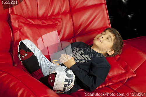 Image of Kid on a red leather sofa