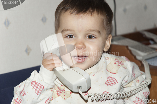 Image of Cute little baby is talking on  phone