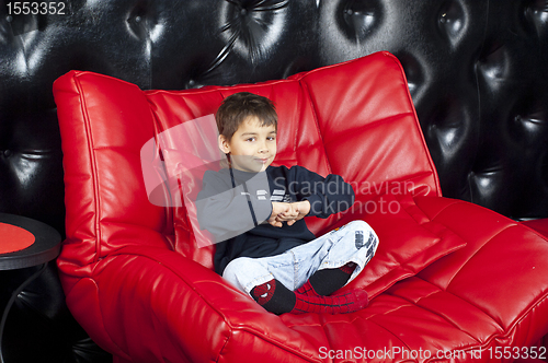 Image of Kid on a red leather sofa