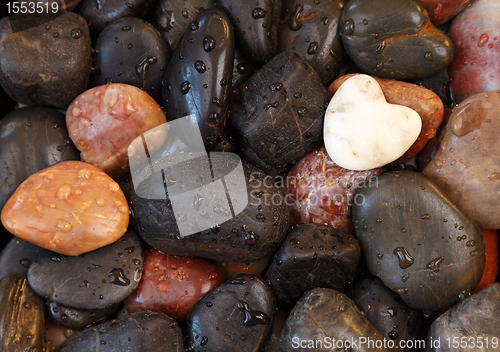 Image of White stone heart surrounded by other stones