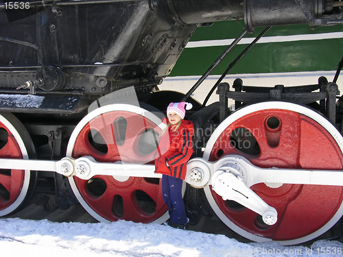 Image of girl and wheels of old locomotive