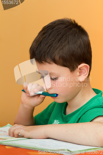 Image of boy doing homework from school in workbook