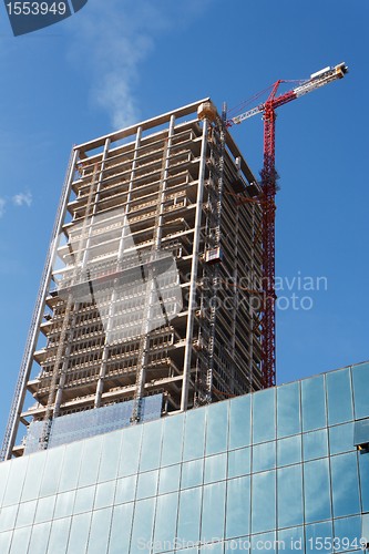 Image of Lifting crane and high building under construction