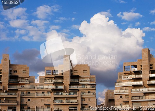 Image of New apartment buildings and clouds above them at sunset