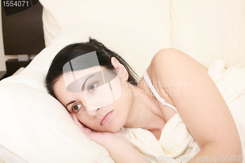 Image of Worried woman in the bed