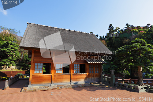 Image of wooden hut with tree and blue sky