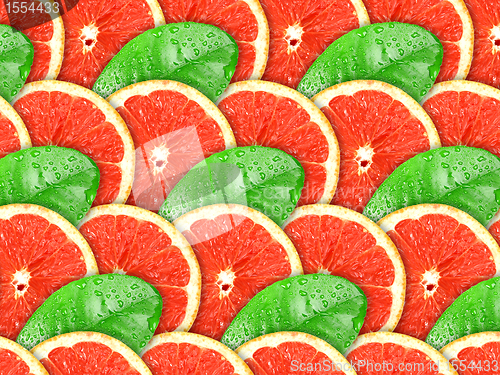 Image of Background of grapefruit slices and green leaf