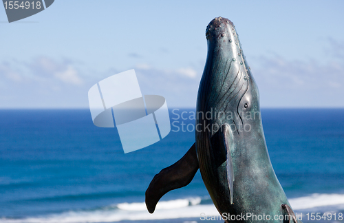 Image of Statue of whale breaching with sea