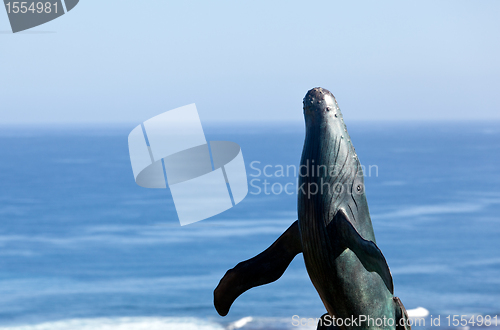 Image of Statue of whale breaching with sea