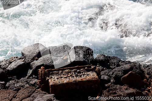 Image of Old engine block dumped by sea