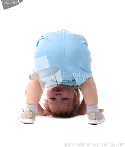 Image of Little boy stands upside-down