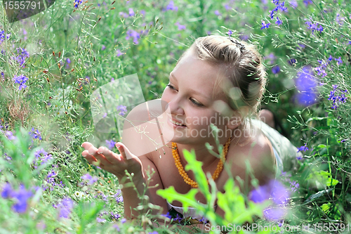 Image of Young girl lying among the flowers