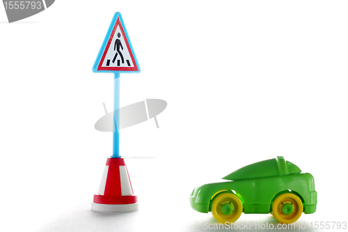 Image of Green car behind pedestrian crossing road sign