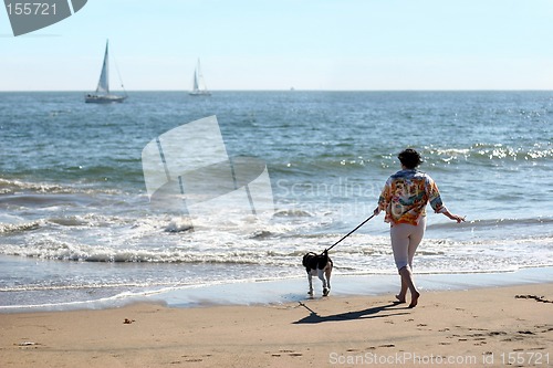 Image of Woman with a dog on the beach