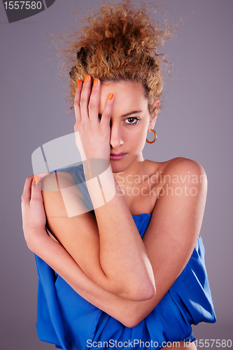 Image of beautiful woman covering half face, with his hands, studio shot