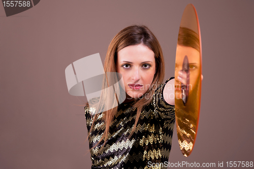 Image of beautiful blonde woman standing holding a golden vinyl disc