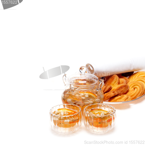 Image of floral tea set and pastry assortment over white