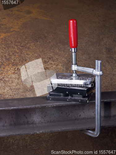 Image of hard disks and clamp in rusty background