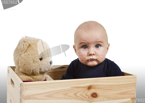 Image of young child with toy in wooden box