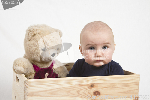 Image of young child with toy in wooden box