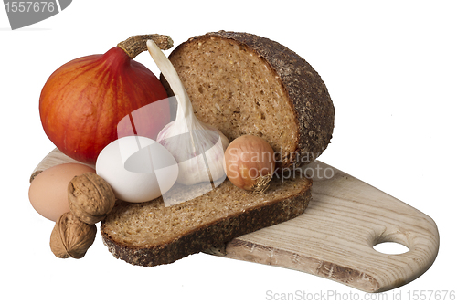 Image of brown bread on shelf with onion, garlic and walnut