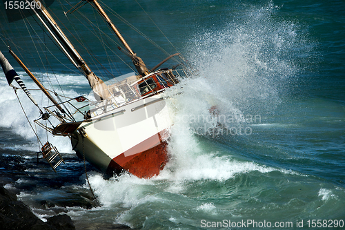 Image of yacht crash on the rocks in stormy weather 