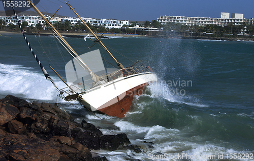 Image of yacht crash on the rocks in stormy weather 