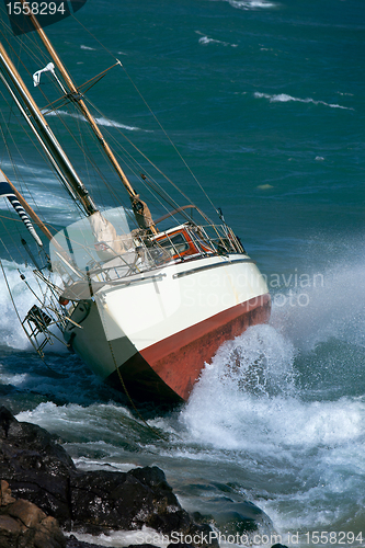 Image of yacht crash on the rocks in stormy weather 