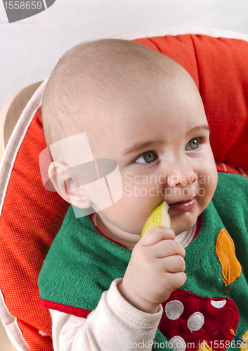 Image of baby sitting and eating an apple