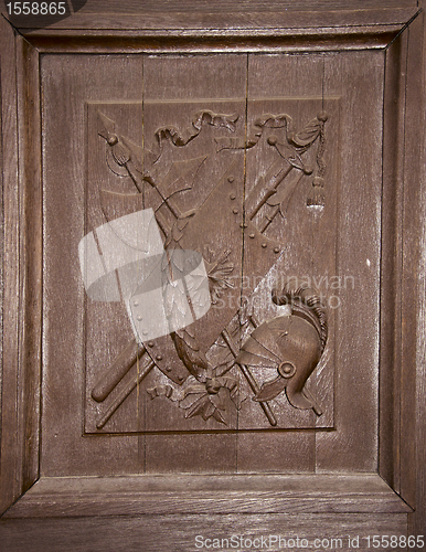 Image of wooden carved door coat arms helmet shield swords 