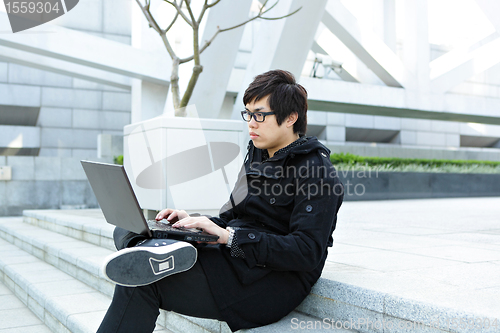 Image of man using computer outdoor