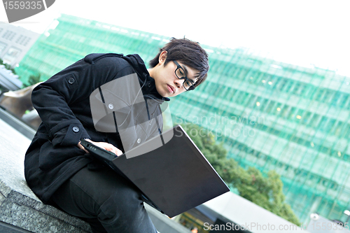 Image of man using computer outdoor