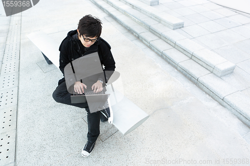 Image of man using computer outdoor