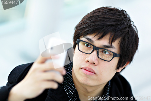 Image of young man taking picture with mobile phone