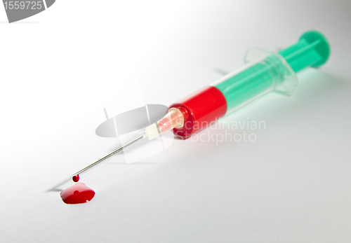 Image of syringe laying on table filled with blood