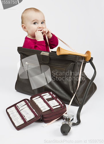 Image of young child sitting in midwifes case