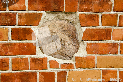 Image of Big stone in red brick wall. Architecture closeup 