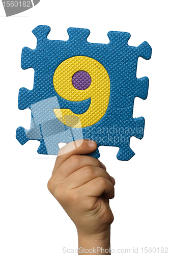 Image of Children hand holding the number Nine. White isolated number