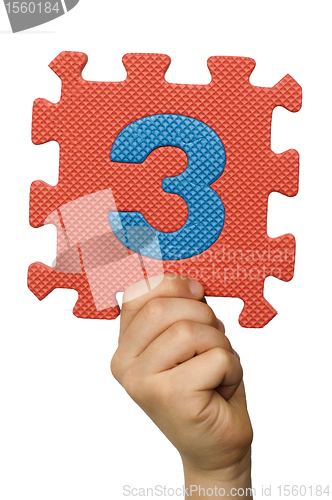 Image of Children hand holding the number Three. White isolated number