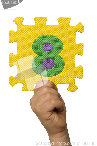 Image of Children hand holding the number Eight. White isolated number