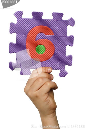 Image of Children hand holding the number Six. White isolated number